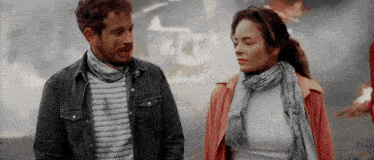 a man and a woman are standing next to each other and talking .