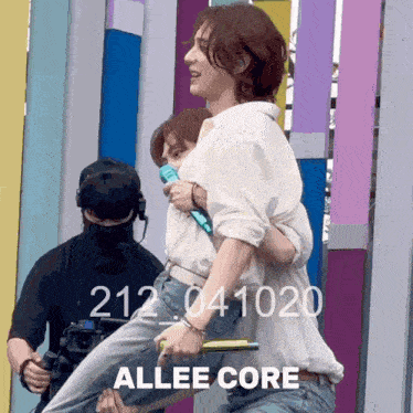 a man is carrying another man on his shoulders with the words allee core on the bottom right