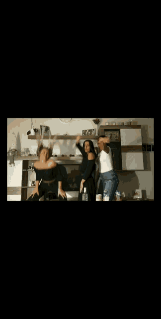 two women are dancing together in a living room in front of a fireplace .