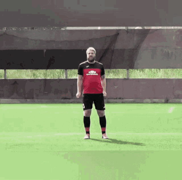 a man with a beard is standing on a soccer field