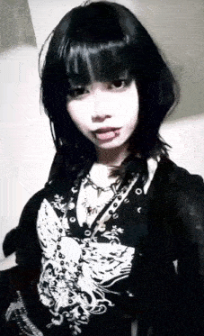 a woman with a piercing in her tongue is wearing a black and white shirt