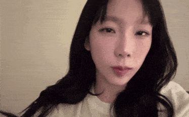 a woman with long black hair looks at the camera
