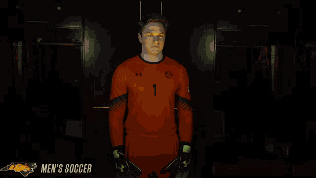 a man in an orange soccer uniform with the number 1 on it