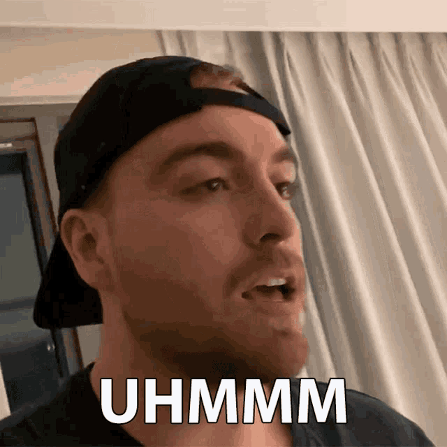 a man wearing a hat says uhmm on his face