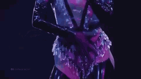 a woman is singing into a microphone on a stage while wearing gloves .