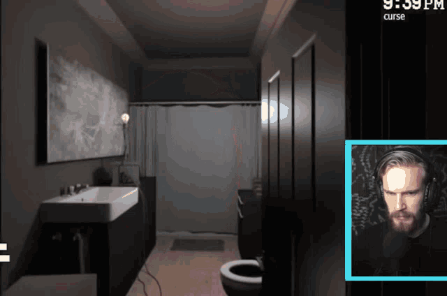 a man playing a video game in a bathroom with the time 9:39 pm