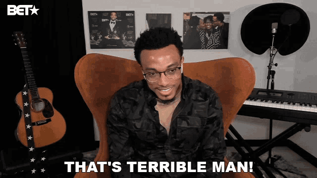 a man is sitting in a chair with the words that 's terrible man behind him