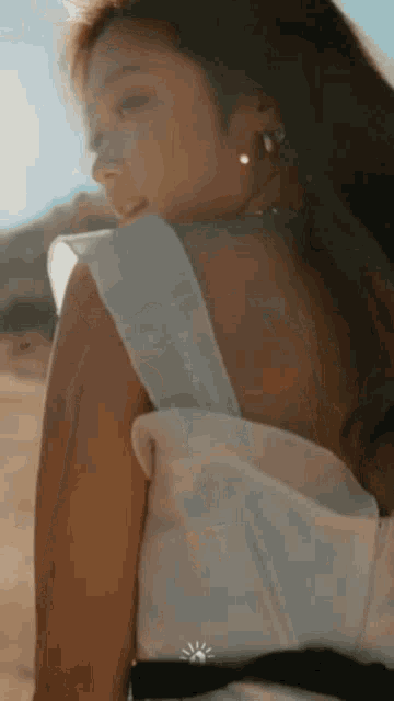 a woman in a white dress is standing on a sandy beach .