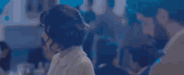 a man and woman are kissing in front of a crowd of people .