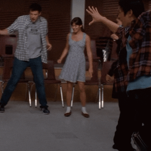 a woman in a dress is dancing with a man in a blue shirt