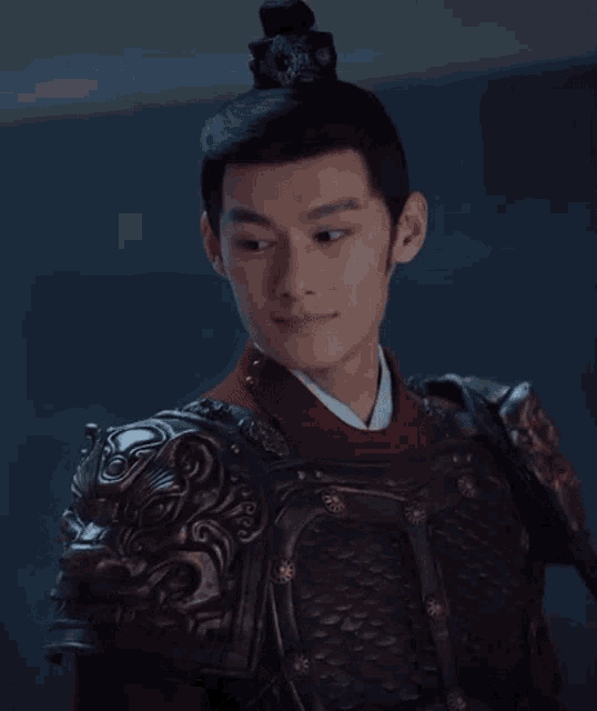 a man is wearing armor and a red shirt .