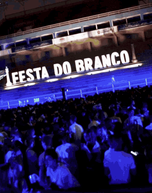 a crowd of people are gathered in front of a large sign that says festa do branco