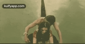 a man is carrying a woman on his back in a rope .