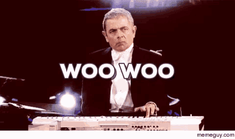 a man in a tuxedo is playing a keyboard in front of a memeguy.com logo