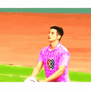 a man in a pink shirt with the number 3 on the front