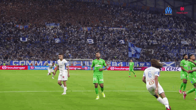 a soccer game is being played in front of a crowd with a banner that says boulanger on it