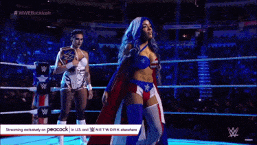 two women are standing in a wrestling ring and one is wearing a red white and blue outfit