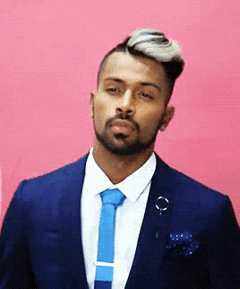 a man with a beard is wearing a suit and tie