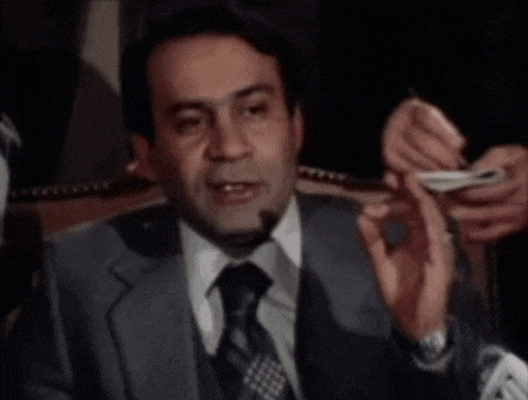 a man in a suit and tie is giving a thumbs up .