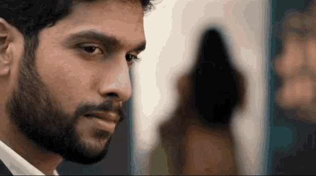 a man with a beard is looking at a woman