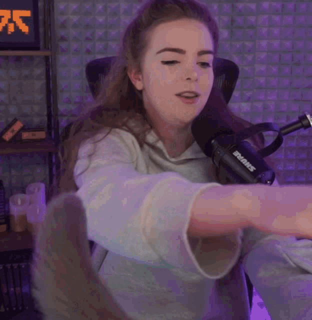 a woman sitting in front of a microphone that says shure on it