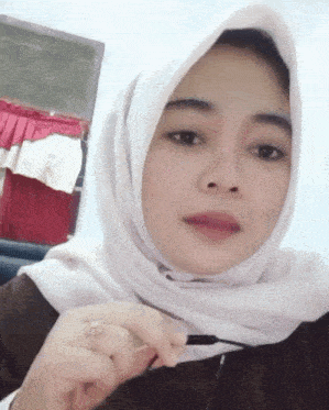 a woman wearing a white hijab and a ring