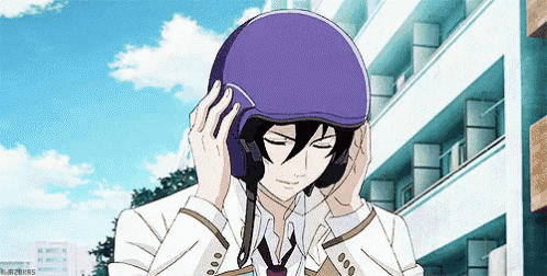 a man in a suit is putting on a purple helmet on his head .