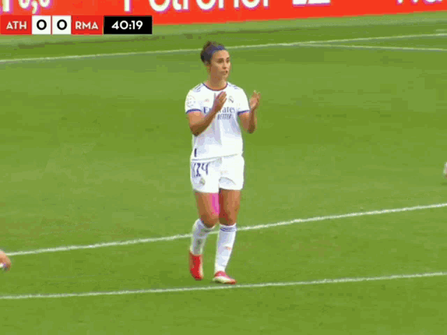 two female soccer players on a field with the score atth 0 rma at the top