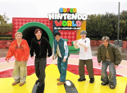 a group of young men are standing in front of a sign that says super nintendo world