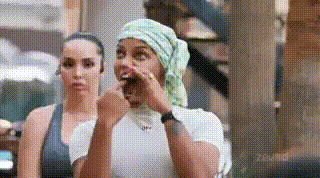 two women are sitting next to each other and one of them is wearing a bandana on her head .