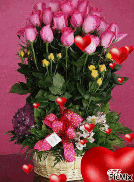 a bouquet of pink roses in a wicker basket with hearts around it