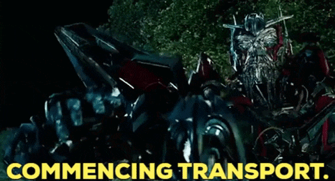 a transformer is sitting in a car with the words commencing transport written below it .