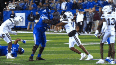 a football player with the number 13 on his back is being tackled by another player