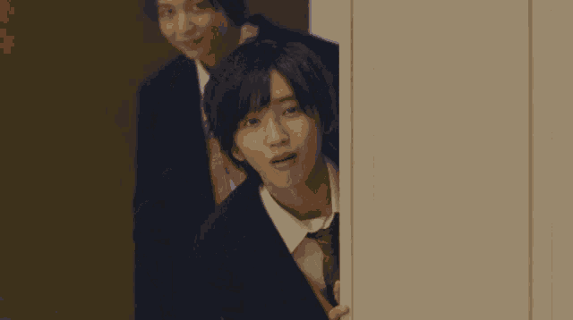 a man in a suit is standing in a hallway with his arms outstretched
