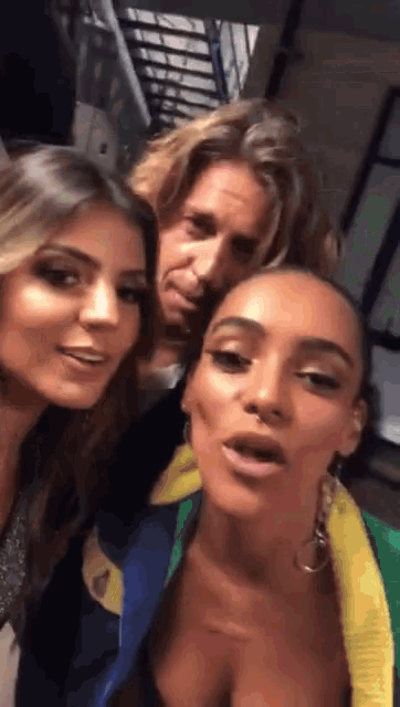 two women and a man are posing for a picture