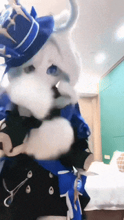 a person in a mascot costume is holding a pair of scissors in their hand