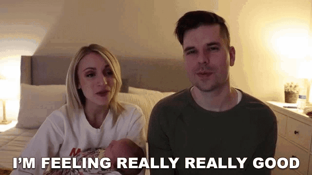 a man and woman are holding a baby and the man is saying i 'm feeling really really good