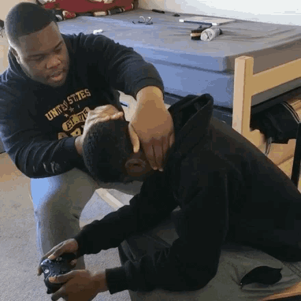 a man wearing a united states t-shirt holds another man 's neck