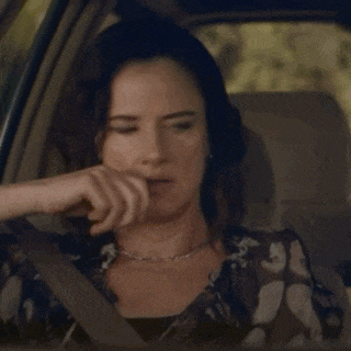 a woman wearing a floral shirt is sitting in a car