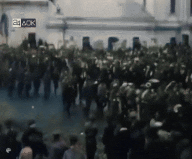 a crowd of people are gathered in front of a building with a 24 ack sign above them