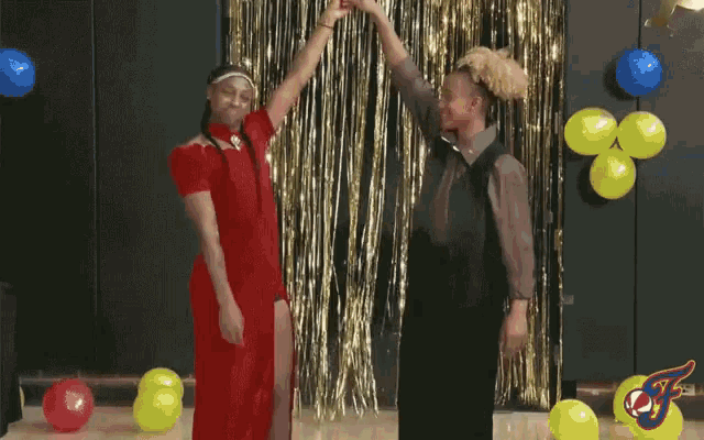 two people are dancing in front of balloons and a sign that says jts on it