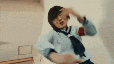 a girl in a school uniform is reaching out to another girl