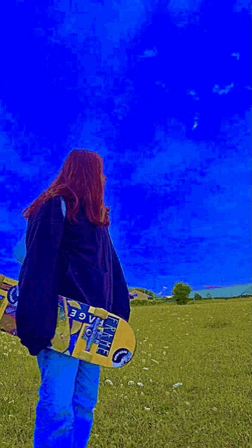 a girl is holding a skateboard in a field with a blue sky behind her