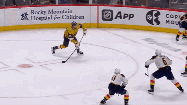 a hockey game is being played in front of a sign for rocky mountain hospital for children