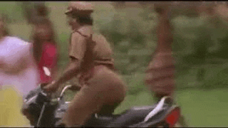 a police officer is riding a motorcycle with a woman behind him .