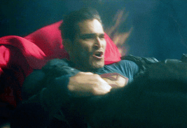 a man in a superman shirt is laying down