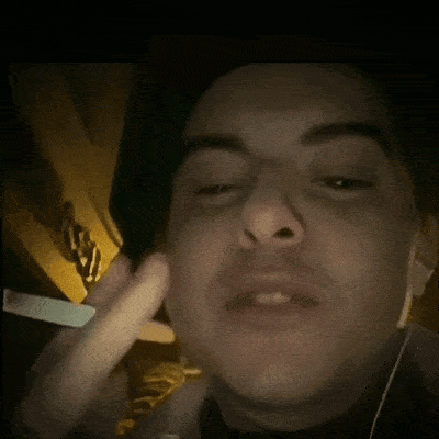 a man wearing headphones is smoking a cigarette in a dark room