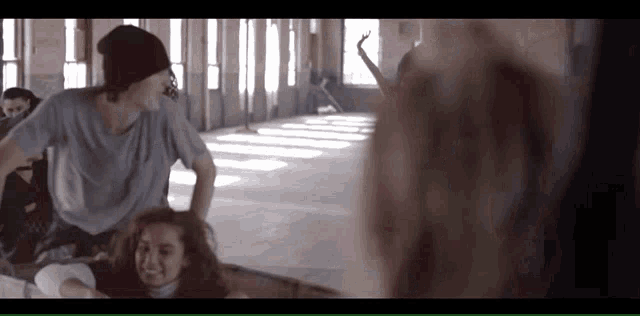 a man in a beanie talks to a woman in a dance studio