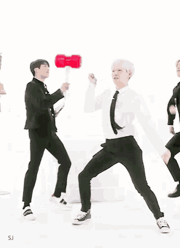 three men in suits and ties are dancing in front of a white background that says sj