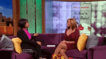 two women sit on a couch in front of a screen that says wendy